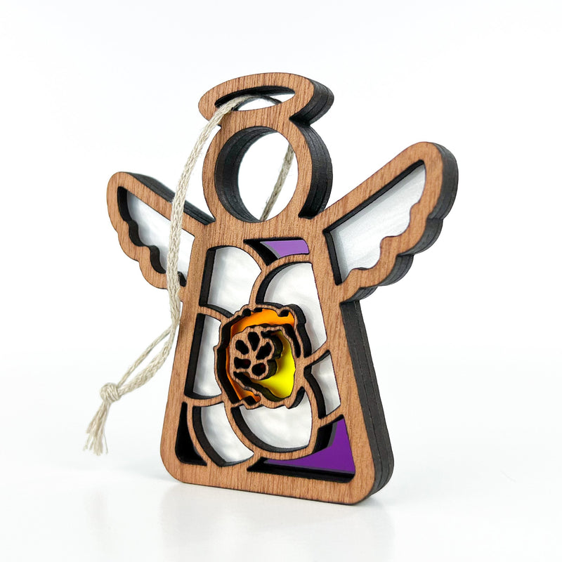 The Forged Flare® Jonquil Ornament is a 3.5" Mother's Angels® figurine featuring a wooden angel with white wings, halo, stained glass accents in purple/yellow, and a March jonquil paw print design. Includes attached string for hanging.