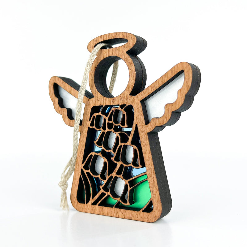 The Forged Flare® Lily of the Valley Ornament is a 3.5" Mother's Angels® figurine featuring carved wings and a multicolored stained-glass effect with a lily of the valley design, symbolizing May's birth flower, hanging from a white string.