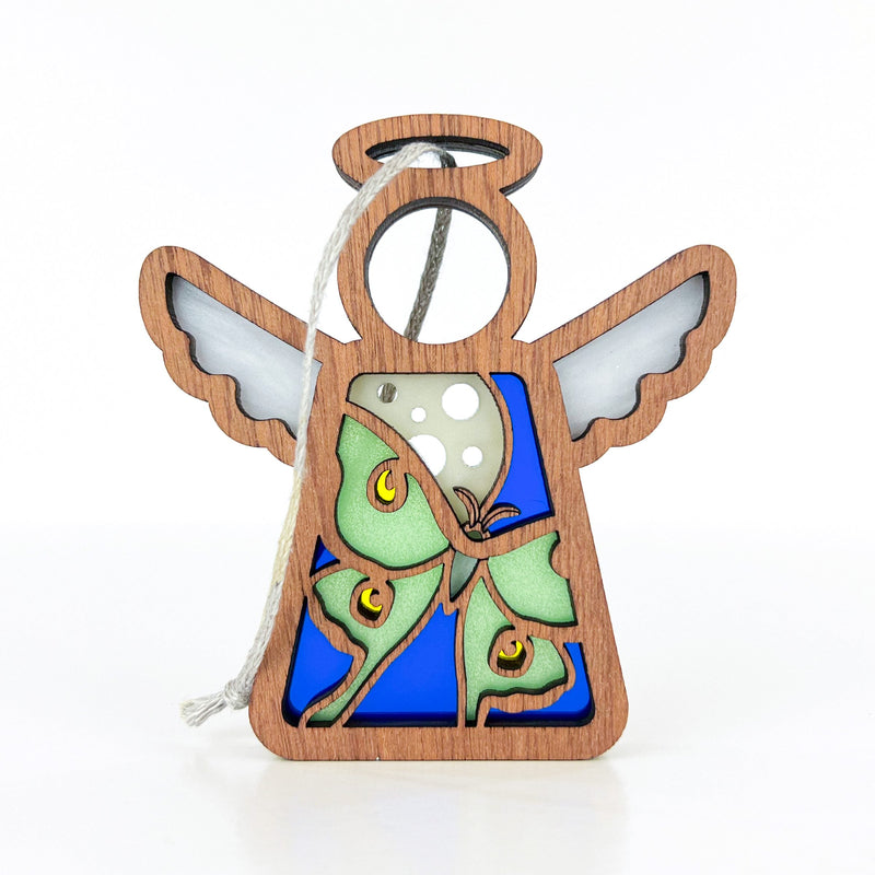 The Luna Moth Ornament by Forged Flare® is a 3.5" Mother's Angels® figurine featuring white wings, a halo, and string loop. Its green moth with yellow eyespots on blue adds unique charm to your Christmas tree decor.