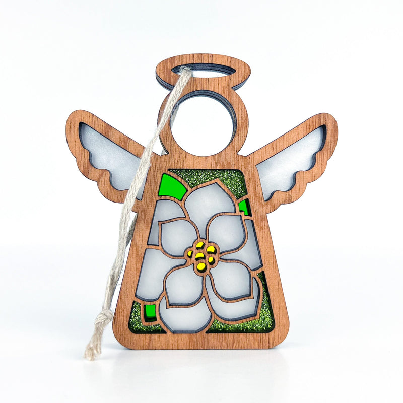 The Magnolia Ornament by Forged Flare® is a 3.5" tall Mother's Angels® angel figurine, featuring white and green stained glass details, a central flower design, and a twine loop for hanging on your Christmas tree.