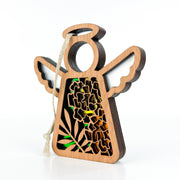The Forged Flare® Marigold Ornament is a 3.5" wooden Mother's Angels® figurine with cutout wings, a circular halo, green and yellow marigold-inspired floral designs, and a looped string for hanging.