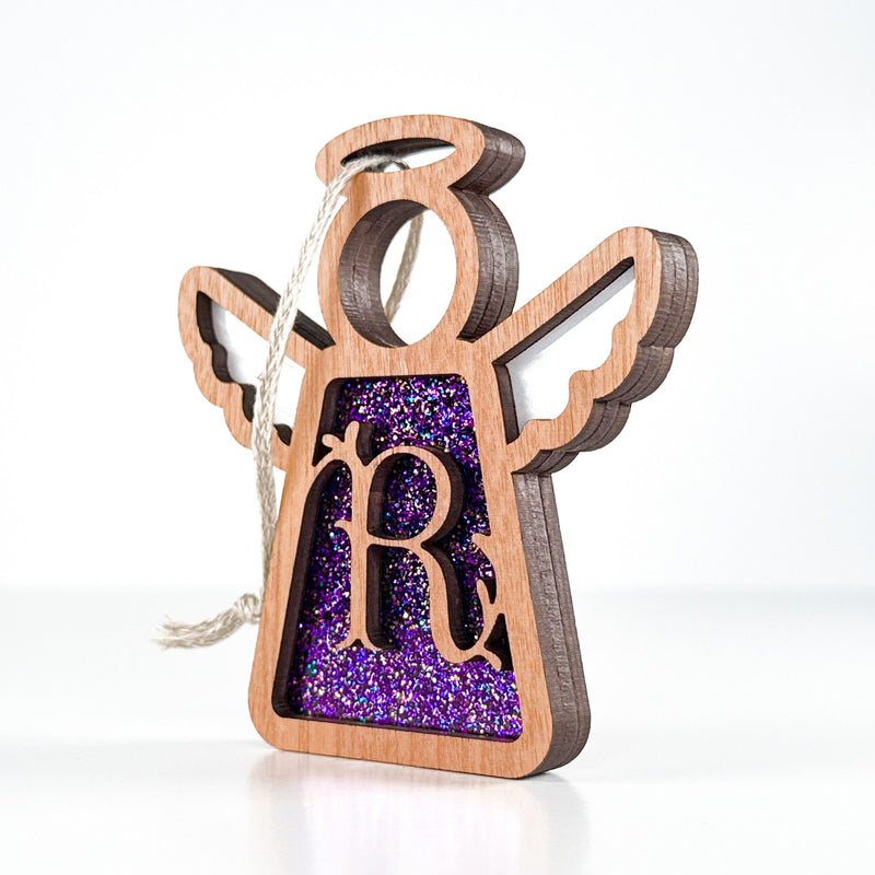 Side view of a purple glitter R initial ornament, displaying its layered artistry for holiday joy
