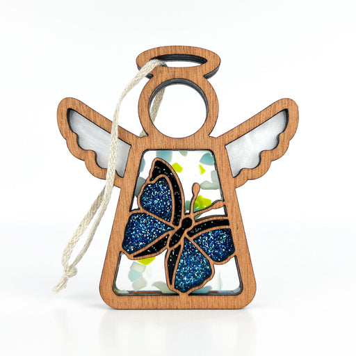 Butterfly decorations hanging on display, featuring the Mother’s Angels® morpho blue butterfly ornament within a wooden angel figurine design.