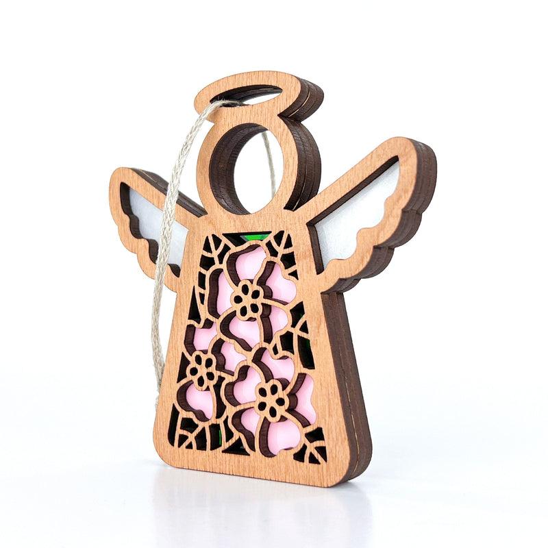 The Forged Flare® Mother's Angels® Pink Evening Primrose Ornament is a 3.5" wooden angel with floral cutouts, white string, and a pink evening primrose backing, shown against a white background.
