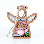 The Forged Flare® Mother's Angels® Pink Peony Ornament is a 3.5" tall wooden angel with frosted white wings, a large pink peony with yellow stamens and green leaves, and a string for hanging—perfect for your Christmas tree.