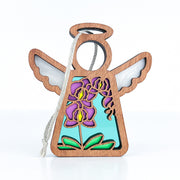 The Forged Flare® Purple Orchid Ornament is a 3.5" wooden angel figurine with a cord, featuring vibrant purple and yellow floral cutouts with green leaves—perfect for any Mother's Angels® collection.