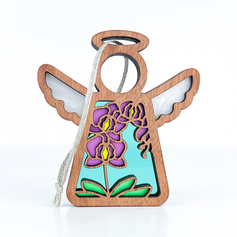 The Forged Flare® Purple Orchid Ornament is a 3.5" wooden angel figurine with a cord, featuring vibrant purple and yellow floral cutouts with green leaves—perfect for any Mother's Angels® collection.