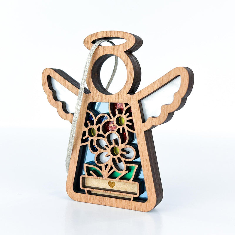 The Forged Flare® Red, White & Bloom Ornament is a 3.5" wooden Mother's Angels® figurine with outstretched wings, colorful flowers, and a gold heart—perfect for your Christmas tree or as a unique patriotic gift. Includes white string for hanging.