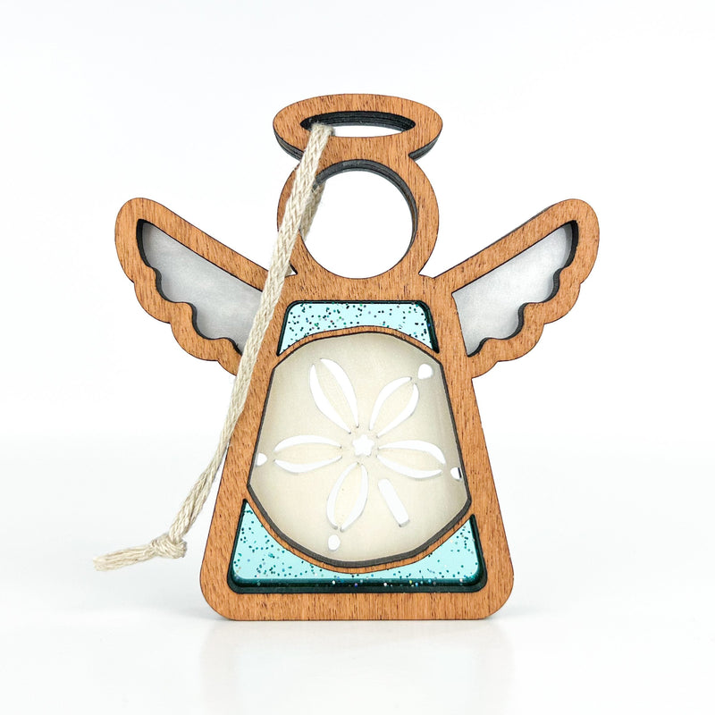 The Sand Dollar Ornament with Imperfections by Forged Flare® is a 3.5" handcrafted Mother's Angels® angel figurine, featuring transparent wings, a sand dollar center, and a twine loop for hanging. Displayed on a white background.