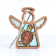 The Forged Flare® Sea Turtle Ornament is a 3.5" Mother's Angels® figurine with transparent wings, a brown and green turtle center, blue bubbly background, and string loop—perfect coastal decor for your beach house.