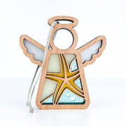 The Forged Flare® Starfish Ornament is a 3.5" Mother's Angels® figurine featuring a wooden angel with white wings, blue and yellow starfish accents, and a hanging string—perfect beach house decor.