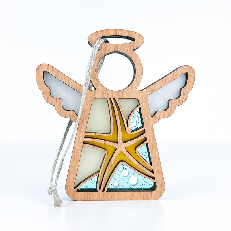 The Forged Flare® Starfish Ornament is a 3.5" Mother's Angels® figurine featuring a wooden angel with white wings, blue and yellow starfish accents, and a hanging string—perfect beach house decor.