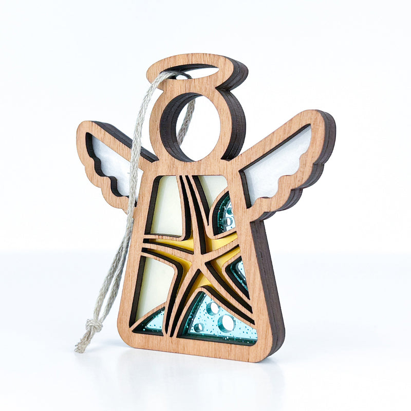 The Starfish Ornament by Forged Flare® is a 3.5" wooden Mother's Angels® figurine with layered details, white wings, and yellow-blue glass-like accents—ideal as unique beach house décor or a thoughtful gift.