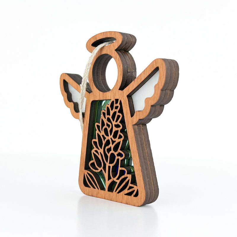 The Forged Flare® Texas Bluebonnet Ornament is a 3.5" Mother's Angels® figurine with cut-out wings and floral details, featuring a white hanging loop and standing upright—ideal as flower decor.