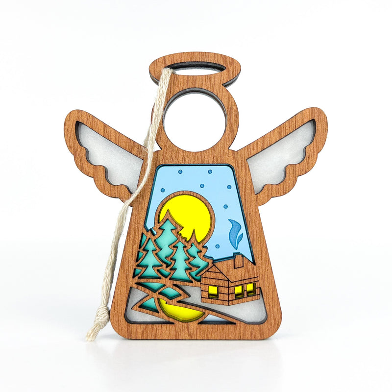 The Forged Flare® Warm Welcome Ornament with Imperfections is a 3.5" handcrafted Mother's Angels® figurine featuring cutout wings and a vibrant winter scene, complete with string for hanging—a unique collectible angel.