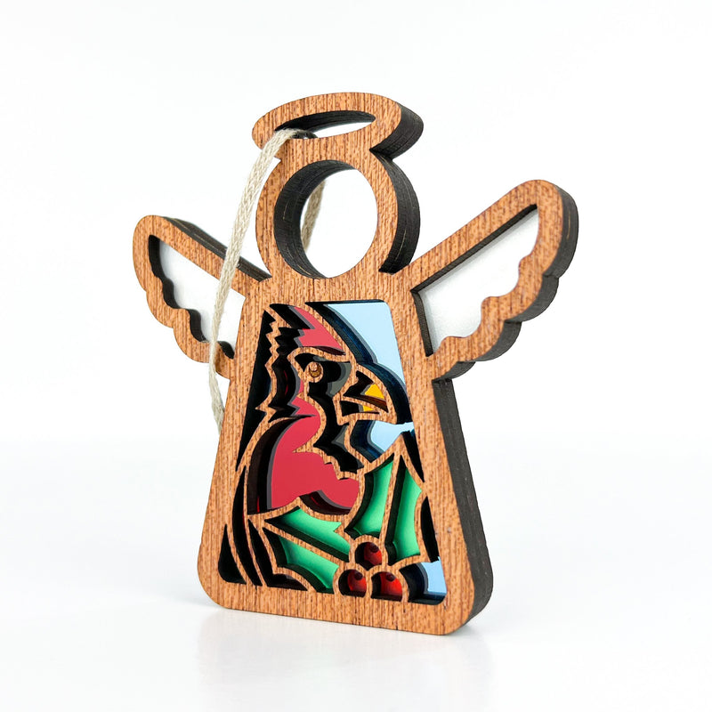 The Forged Flare® Mother's Angels® Winter Cardinal Ornament is a 3.5" handcrafted wooden angel figurine with cut-out wings, a halo, and a stained glass-style cardinal centerpiece with holly, perfect for hanging display.