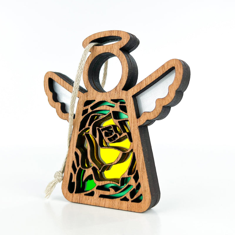 The Forged Flare® Yellow Rose Ornament is a 3.5" Mother's Angels® figurine with white wings, a halo, stained-glass June Birth Flower (yellow rose) and green leaves, plus a twine loop for hanging. Background is plain white.