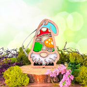 The Forged Flare® Toadstool Mushroom Ornament (3.75" H) by Nature's Gnomes™ features a colorful gnome with a red, white-spotted toadstool on a wood slice, with moss and pink flowers, perfect as a whimsical garden gift.