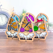 The Forged Flare® Nature’s Gnomes™ 3-piece bundle features California Poppy, Monarch Butterfly, and Toadstool Mushroom gnomes (3.75"H), perfect for whimsical Christmas tree decor or gifts.