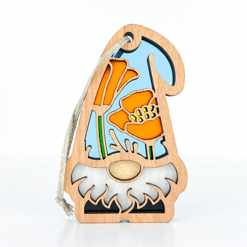 The California Poppy Ornament by Forged Flare® features a 3.75" garden gnome with a white beard, light blue hat, and orange poppy flowers. Part of Nature's Gnomes™, it comes with a string loop for easy hanging.
