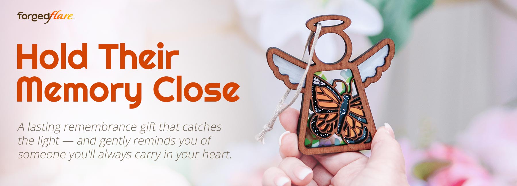 A beautiful monarch butterfly ornament being held up in the sunlight. Text reads: Hold Their Memory Close. A lasting remembrance gift that catches the light — and gently reminds you of someone you'll always carry in your heart.