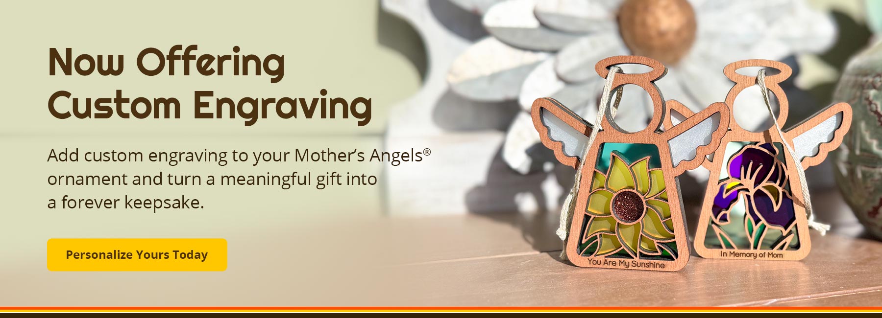 Two 'Mother's Angels' ornaments with custom engravings on a wooden surface. Text reads: Now Offering Custom Engraving. Add a custom engraving to your Mother’s Angels® ornament and turn a meaningful gift into a forever keepsake. Personalize Yours Today.