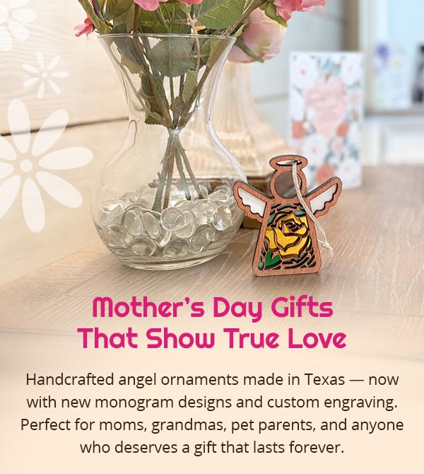 Yellow rose Mother’s Angels® ornament displayed next to a vase of pink flowers. There's a blurred desk with a greeting card in the background and a wedding photo of parents. Text reads: Mother's Day Gifts That Show True Love. Handcrafted angel ornaments made in Texas — now with new monogram designs and custom engraving. Perfect for moms, grandmas, pet parents, and anyone who deserves a gift that lasts forever.
