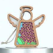A wooden angel ornament with a cutout design featuring purple lilac flowers, green leaves, and a blue background. The angel has a halo, wings, and a braided linen string for hanging. This lilac ornament is intricately designed and brightly colored.