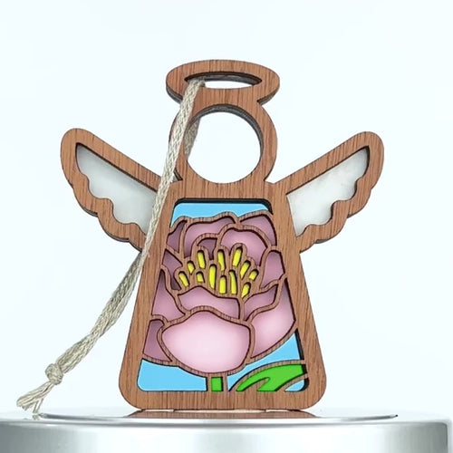 A small wooden stained glass–style angel ornament with an intricate pink peony design in the center. The angel has raised wings, a halo, and a string loop for hanging. 