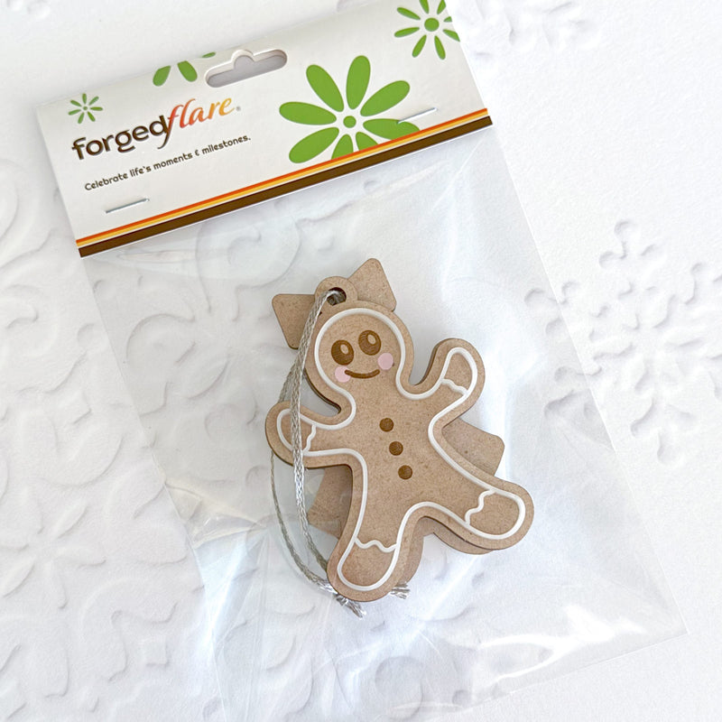 The Sweet Gingerbread Cookies Ornaments: Boy & Girl Set (3.5") by Forged Flare® features brown gingerbread figures with white icing and smiles, each in clear packaging labeled "Forged Flare"—a perfect festive touch for gingerbread lovers.