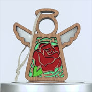 A wooden angel ornament with carved wings and a red rose on its body. The red rose ornament features delicate green leaves, adding charm to its design. With a hole at the top for hanging, it's threaded with a braided linen string. The background is white.