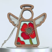 A wooden angel ornament with outstretched wings, featuring a stained glass-style red poppy design in the center. The angel, known as the poppy ornament, has a simple circular head with a halo and is attached to a braided linen string for hanging. The background is plain white.